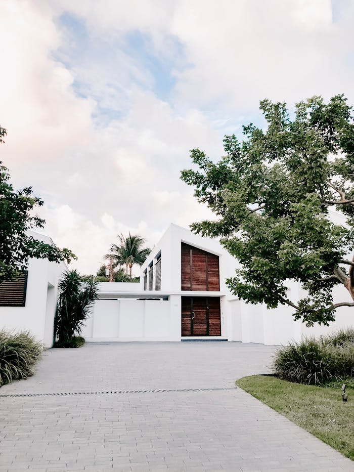 services-03 Contemporary minimalist home exterior with lush landscaping and open driveway.